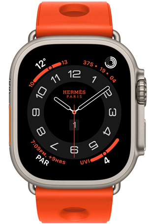 Apple Watch Hermès Ultra 3, Circulaire analog watch face, (hour, minute and second hands, complications: Weather, activity rings, Paris time and UV Index), titanium case, natural colour, right side exterior, Digital Crown, raised side button, paired with Scub'H Diving band, orange néon colour (bright orange), molded rubber material, circular cutouts centred