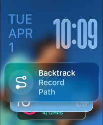 Three Apple Watch models: centre Apple Watch Ultra 2 in Natural Titanium with a Black Trail Loop band, face shows Watch app and Backtrack widget; right Apple Watch in Jet Black with an Aquamarine Braided Solo Loop band, face shows a Live Translation conversation with Grandma; left Apple Watch in Silver with a Tangerine Sport band, face shows Outdoor Run with play button in Workout app