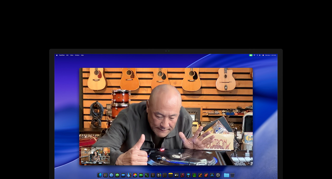 Videopuhelussa oleva henkilö katselee tarkemmin levysoitinta musiikkiliikkeessä, hän pysyy keskellä kuvaa Center Stage ‑kameran ansiosta