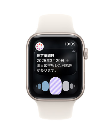 スターライトアルミニウムケースのApple Watch SE 3。ヘルスケアアプリの周期記録から推定された排卵日の通知が表示されている。Digital Crownが見えており、スターライトのスポーツバンドが付いている