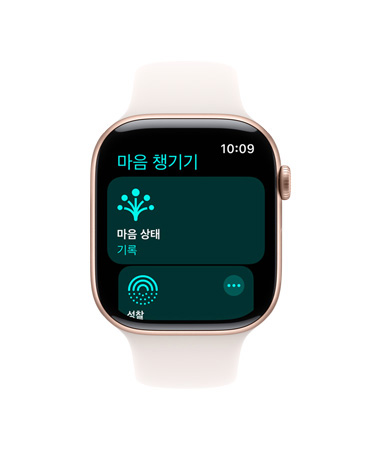 ‘마음 챙기기’ 앱이 열려 있고 오른쪽 옆면에 Digital Crown이 보이는 로즈 골드 색상 알루미늄 케이스의 Apple Watch Series 11, 그리고 라이트 블러시 스포츠 밴드
