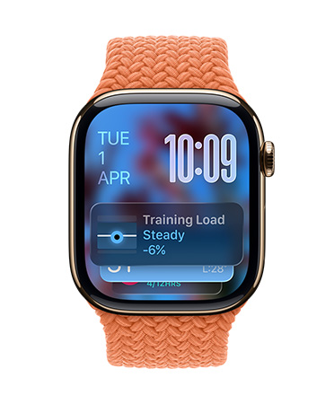 Apple Watch in Rose Gold with a braided strap in Tangerine, face shows date at top left, time with stacked numerals at top right, Training Load widget at the bottom, all in translucent Liquid Glass