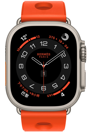 原色鈦金屬錶殼 Apple Watch Hermès Ultra 3，採用 Circulaire 指針錶面 (小時、分鐘與秒針，以及多項複雜功能，包括天氣、活動記錄圓圈、巴黎時間與紫外線指數)，右側外觀上有數位錶冠和凸起的側邊按鈕，搭配 Orange Néon 霓虹橙色 (亮橙色) Scub’H Diving 錶帶，錶帶由橡膠材質模塑成型，中央有圓孔鏤空設計