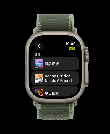 Apple Watch Ultra 3，展示原色鈦金屬錶殼，搭配綠色配霓虹綠色越野錶環，螢幕顯示 Apple Music 的音樂與 podcast 建議