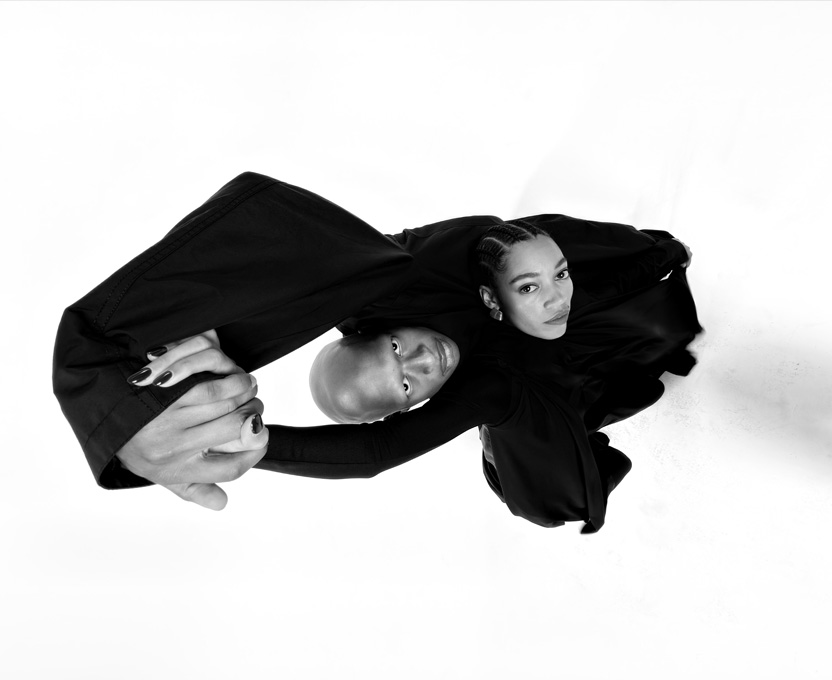 Mustavalkoinen laajakulmakuva kahdesta ihmisestä esittelee iPhone 17 Pron ultralaajakulmakameran ominaisuuksia