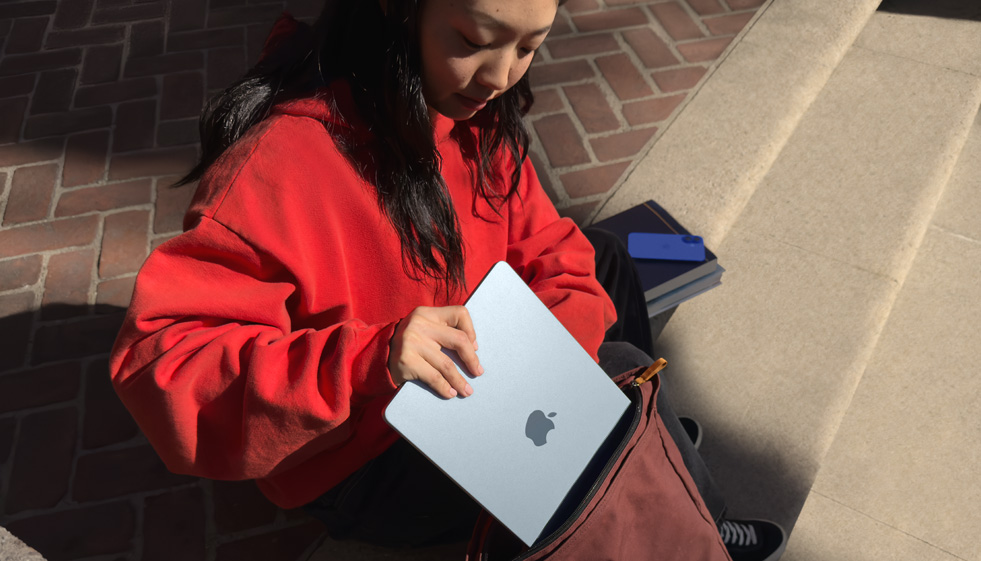 Student stavlja MacBook Air u svoj ruksak.